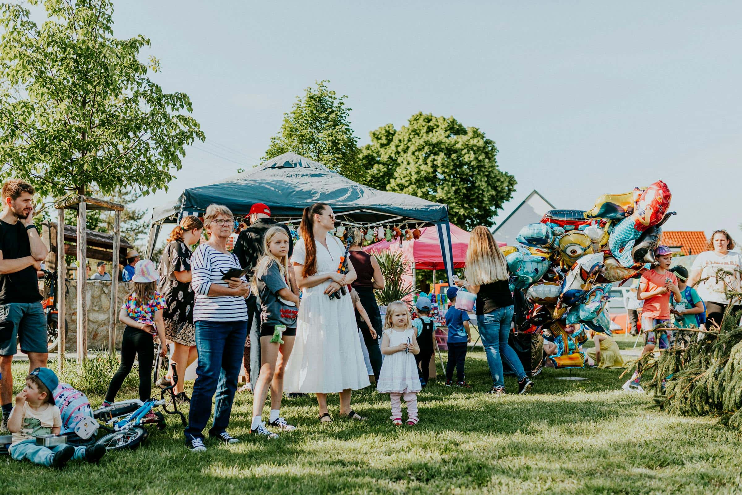 Family day all'aperto con famiglie, stand e palloncini
